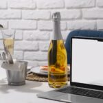 En flaska vin intill en dator