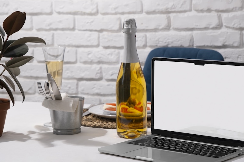 En flaska vin intill en dator